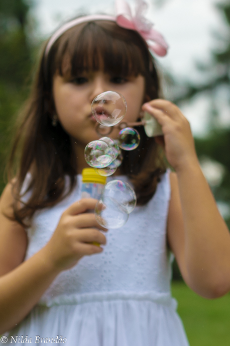 Menina fazendo bolinha de sabão