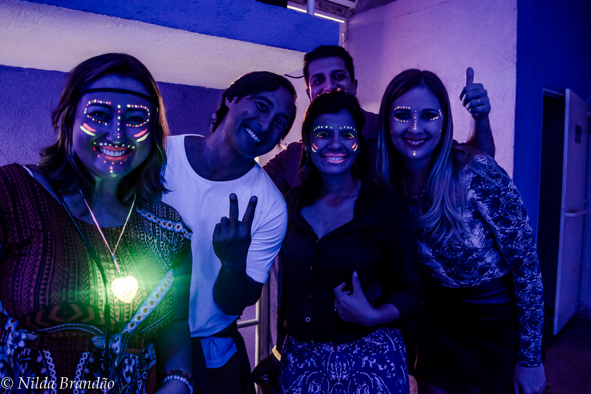 Amigos posam para fotos com luz de neon