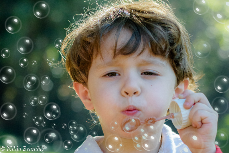 Menino brincando de fazer bolhas de sabão