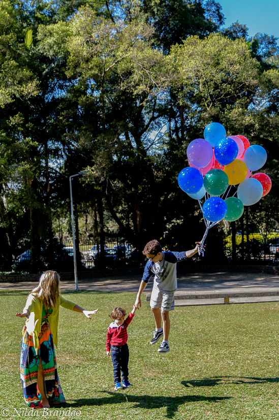 Familia no paque brincando com balões de gas helio