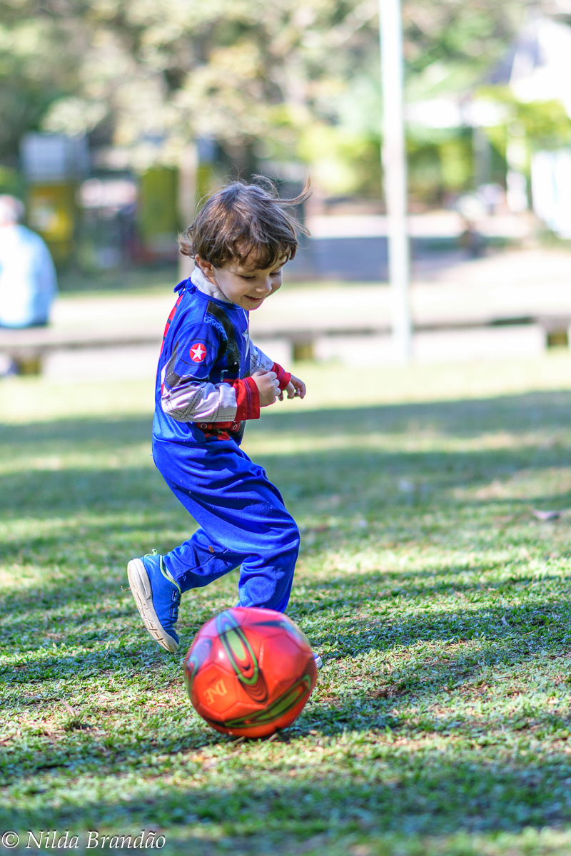 Menino jogando bola no parque