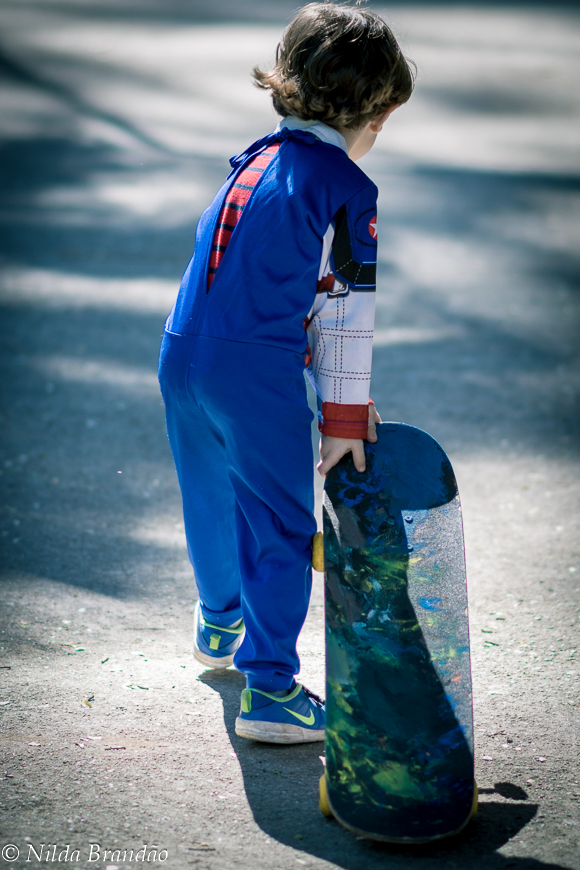 Menino carregando o skate no parque