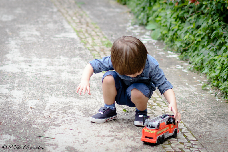 Menino brinca com seu carrinho de bombeiro