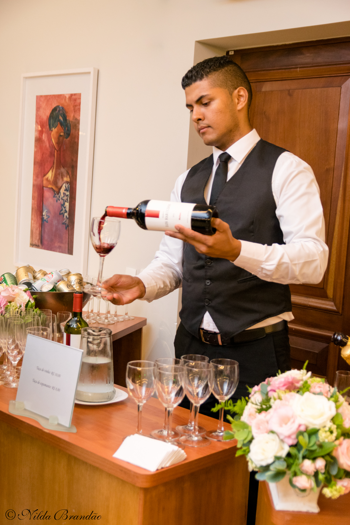 Garçon serve vinho