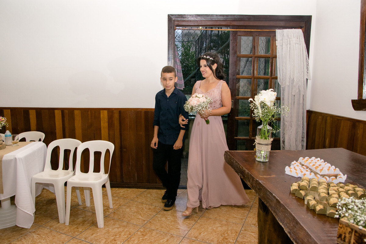 O filho mais velho do casal levou a mãe a té o altar.