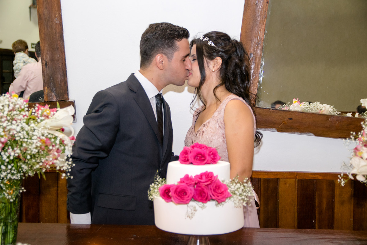 Noivos trocam beijo apaixonado na cerimonia de casamento
