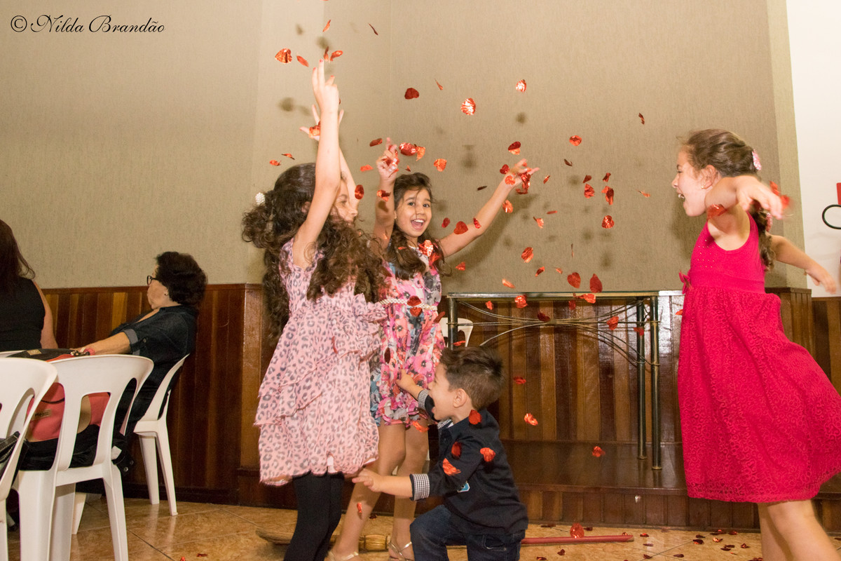 Crianças brincam com confetes na festa de casamento de Rafael e Gabriela
