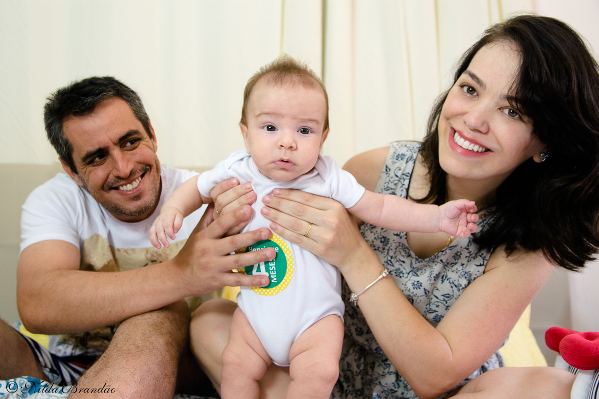 Pais sorriem orgulhosos apresentando o bebê