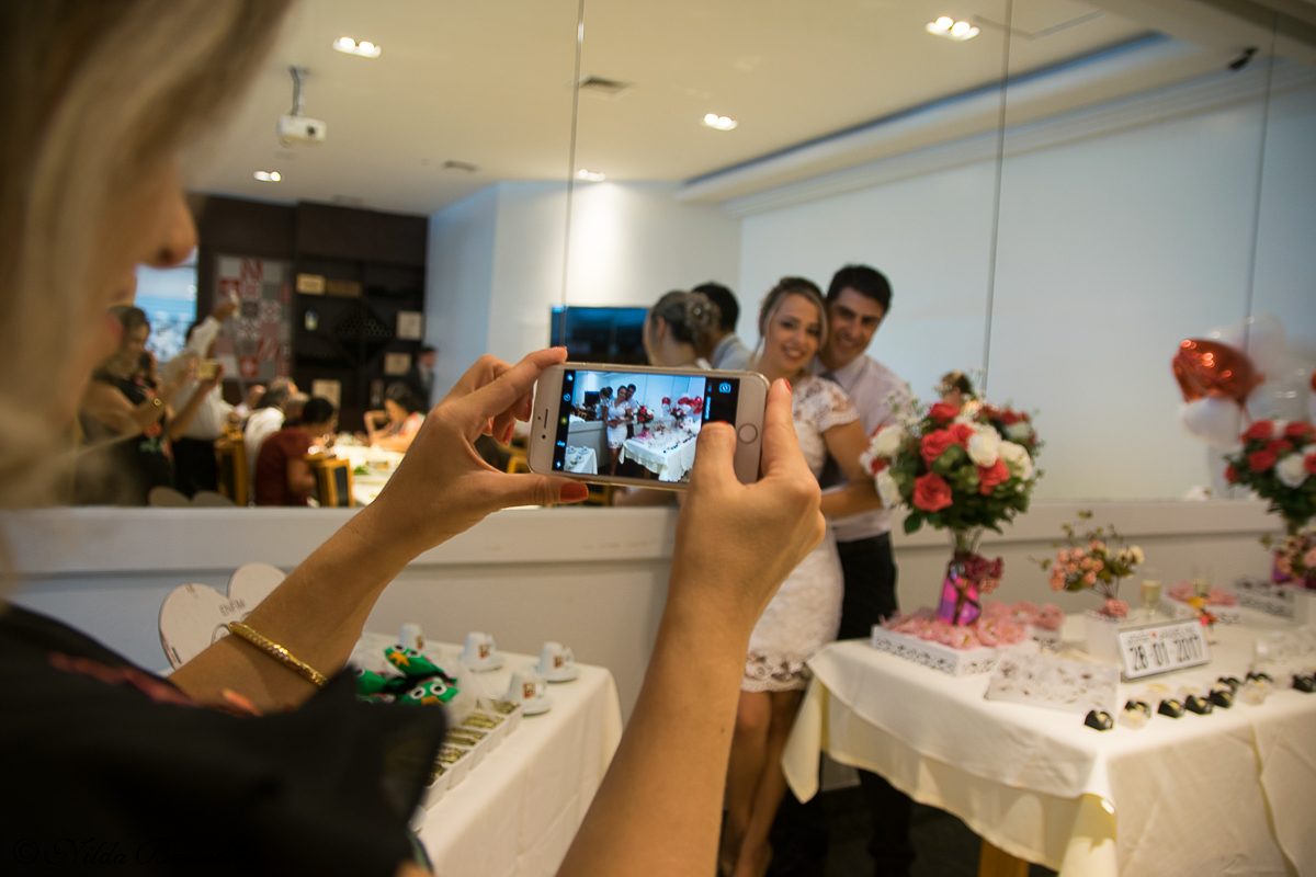 Convidados registram a festa com celulares.
