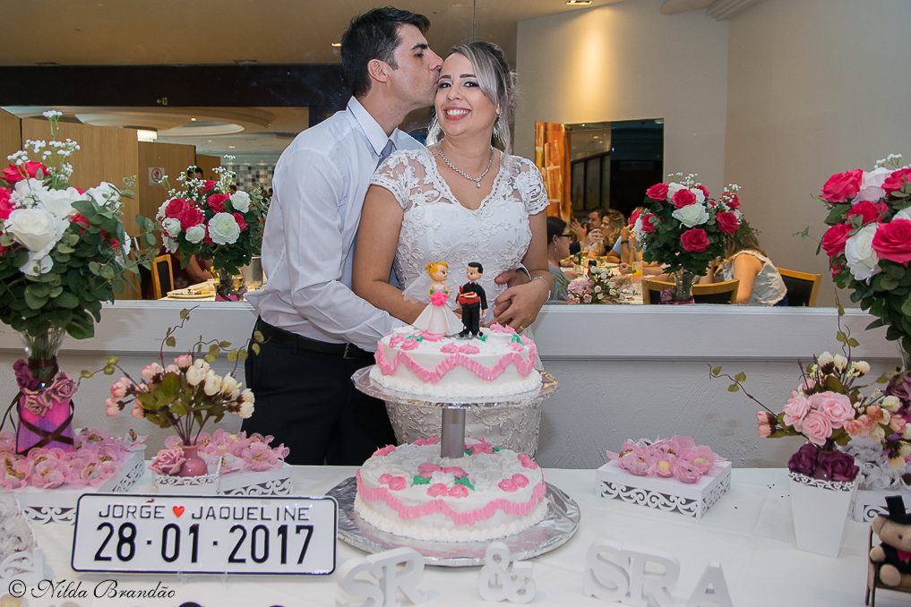 Momento meigo, noivo beija a testa da noiva na recepção do casamento.
