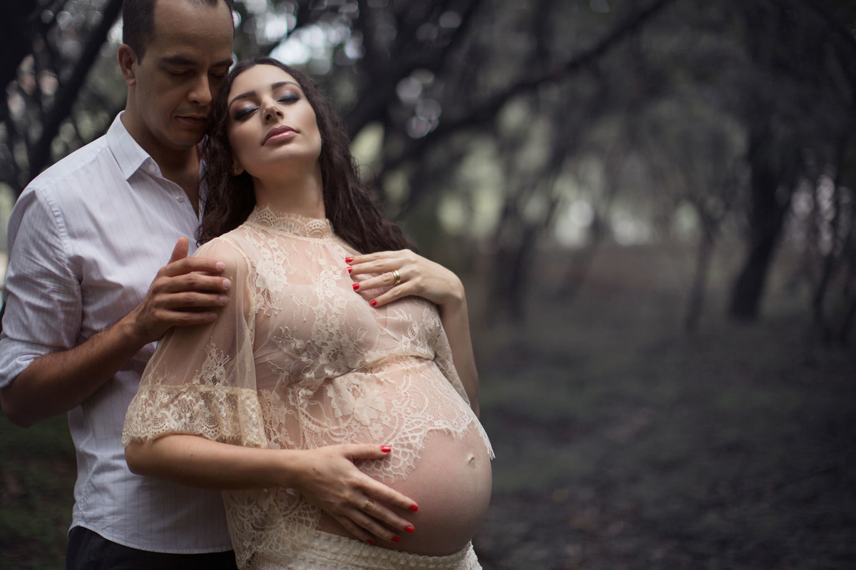 Grávida com seu marido em floresta. Fotografada pelo fotógrafo de gestante Rafael Ohana em Brasília-DF.