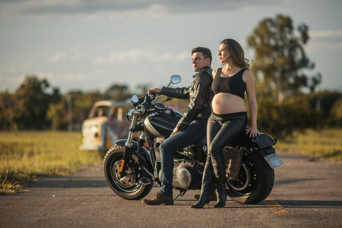 Gestante sentada em moto Harley Davidson com seu marido. Foto feita pelo fotografo de gestantes Rafael Ohana em Brasília-DF