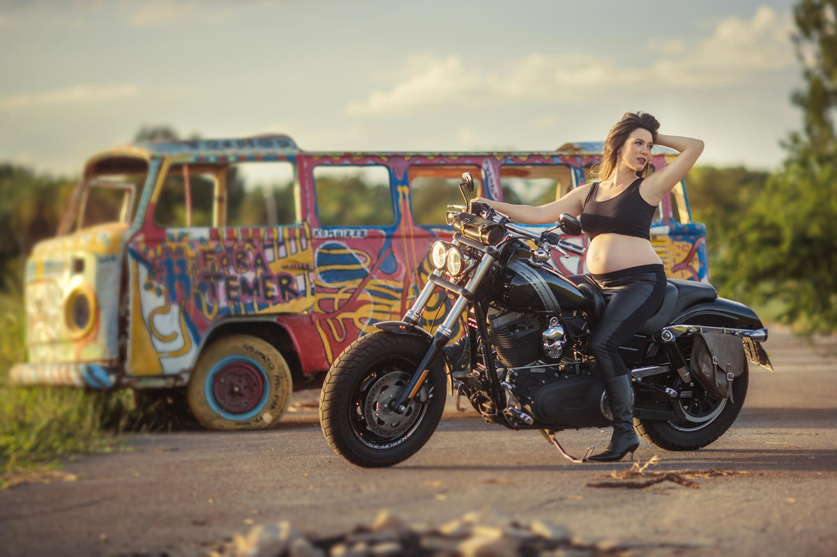 Gestante fazendo charme em cima de moto Harley Davidson. Foto feita pelo fotografo de gestantes Rafael Ohana em Brasília-DF