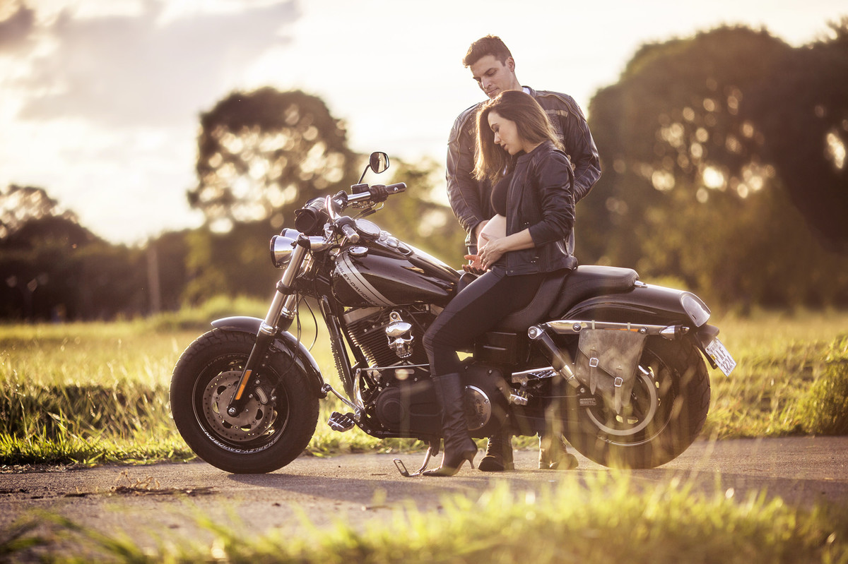Gestante sentada em moto Harley Davidson do seu marido. Foto feita pelo fotografo de gestantes Rafael Ohana em Brasília-DF