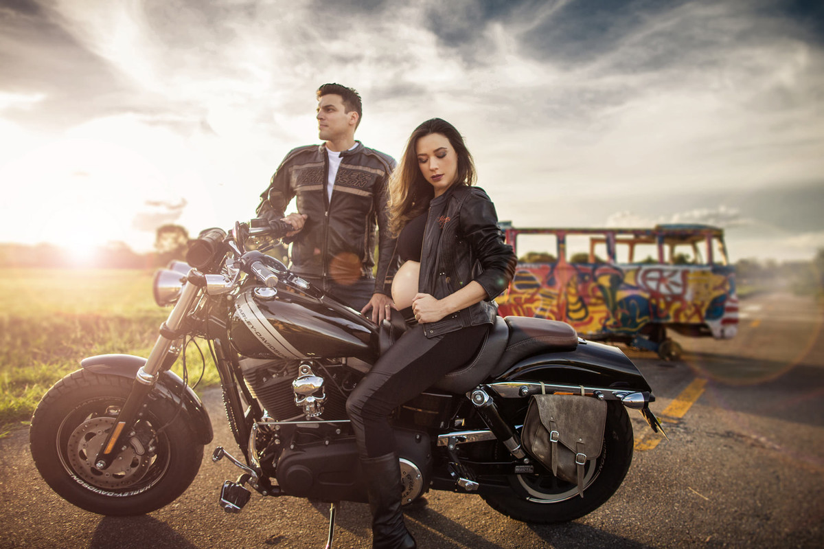 Grávida fazendo charme em cima de moto Harley Davidson com seu marido. Foto feita pelo fotografo de gestantes Rafael Ohana em Brasília-DF