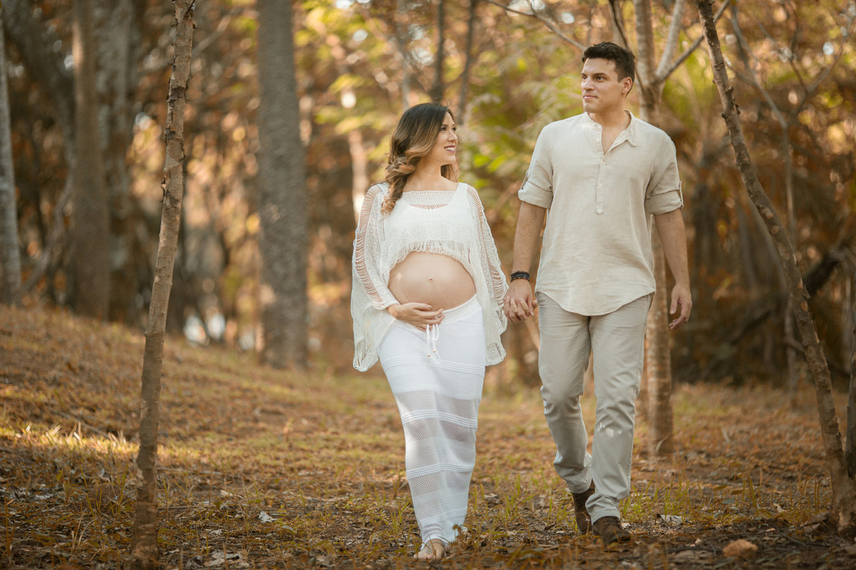 Gestante pesseando na floresta com seu esposo. Foto feita pelo fotografo de gestante Rafael Ohana em Brasilia-DF