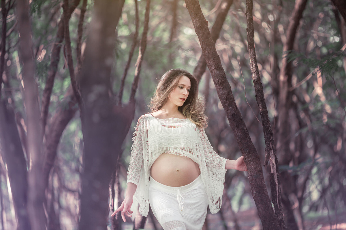 Gestante passeando na floresta de folhas roxas. Foto feita pelo fotografo de gestante Rafael Ohana em Brasilia-DF