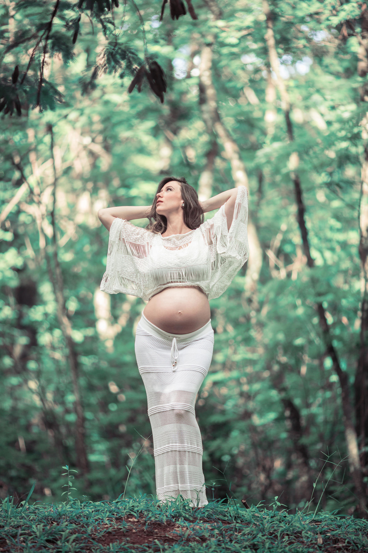 Gestante se espreguiçando na floresta. Foto feita pelo fotografo de gestante Rafael Ohana em Brasilia-DF