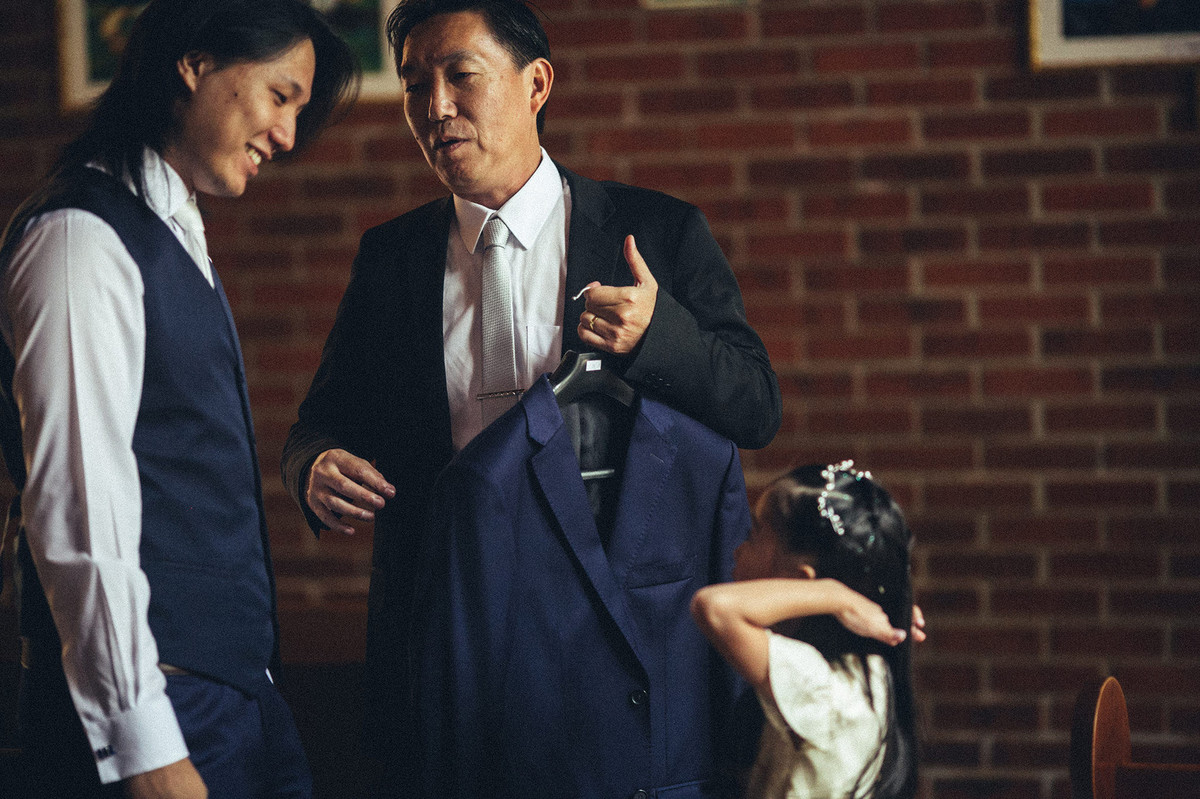 Noivo sorrindo para menina em casamento