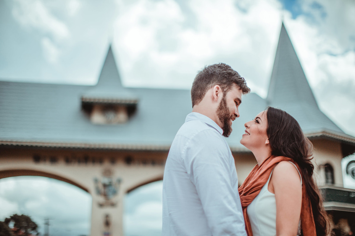 Casal se olhando no pórtico de Gramado-RS. Foto feita pelo fotógrafo de casamento Rafael Ohana.