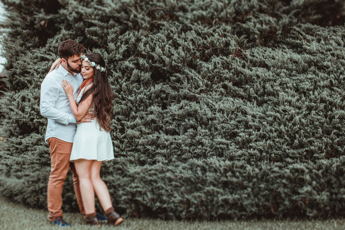 Casal se beijando perto de cipreste em condomínio em Gramado-RS. Foto feita pelo fotógrafo de casamento Rafael Ohana