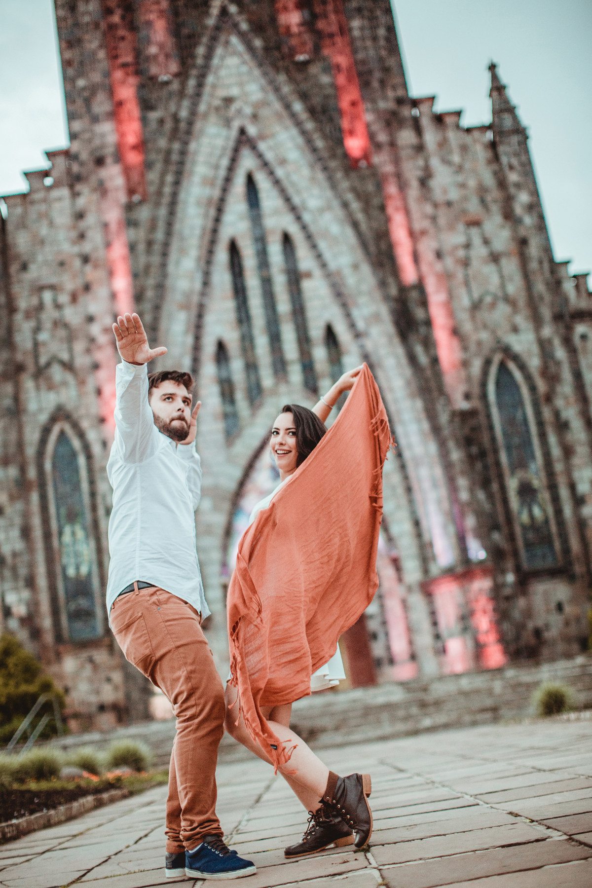 Casal se divertindo em ensaio romântico em frente a Igreja Matriz de Canela-RS. Foto feita pelo fotógrafo de casamento Rafael Ohana