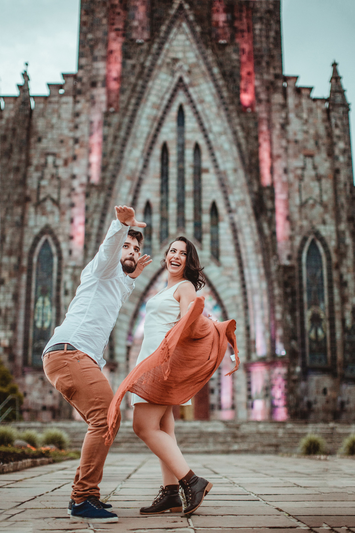Casal se divertindo em ensaio romântico em frente a Igreja Matriz de Canela-RS. Foto feita pelo fotógrafo de casamento Rafael Ohana