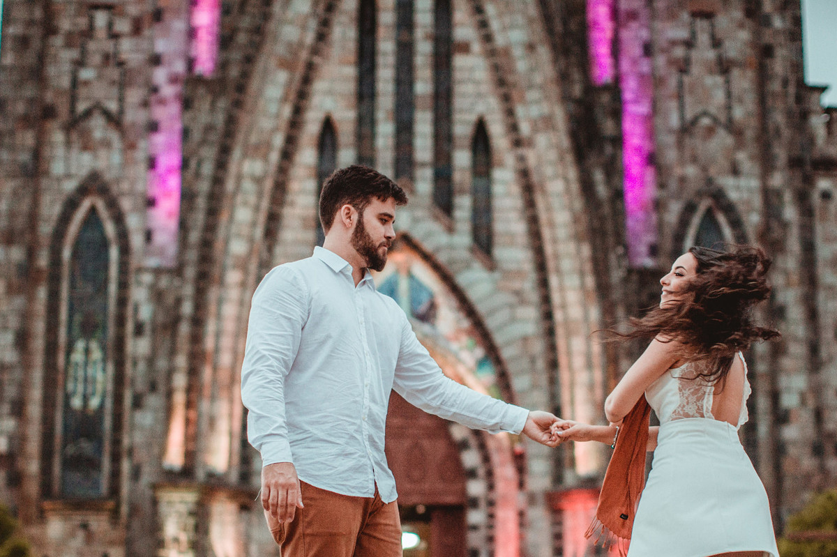 Casal se divertindo em ensaio romântico em frente a Igreja Matriz de Canela-RS. Foto feita pelo fotógrafo de casamento Rafael Ohana