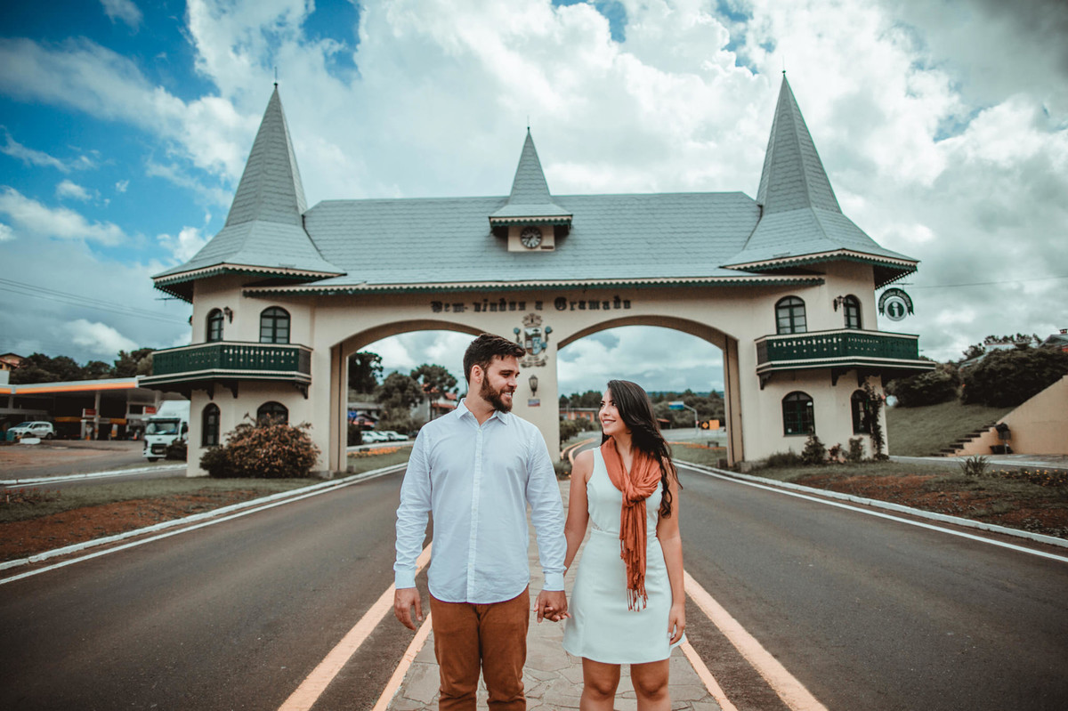 Casal se olhando de mãos dadas em pórtico de Gramado-RS. Foto feita pelo fotógrafo de casamento Rafael Ohana