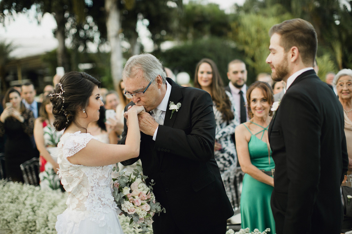 Pai da noiva se despedindo da noiva beijando sua mão