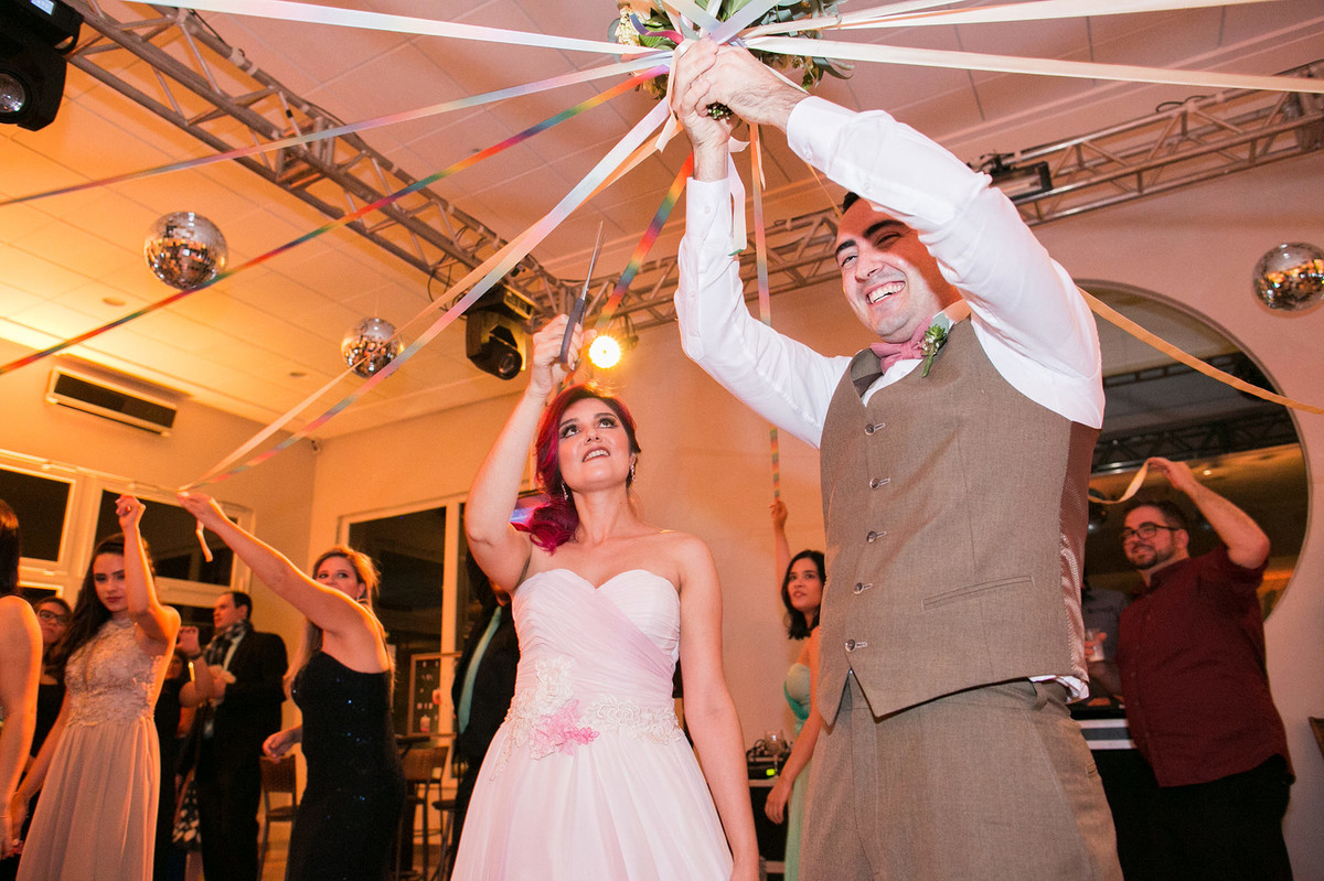 Noiva cortando fitas de buquê de casamento