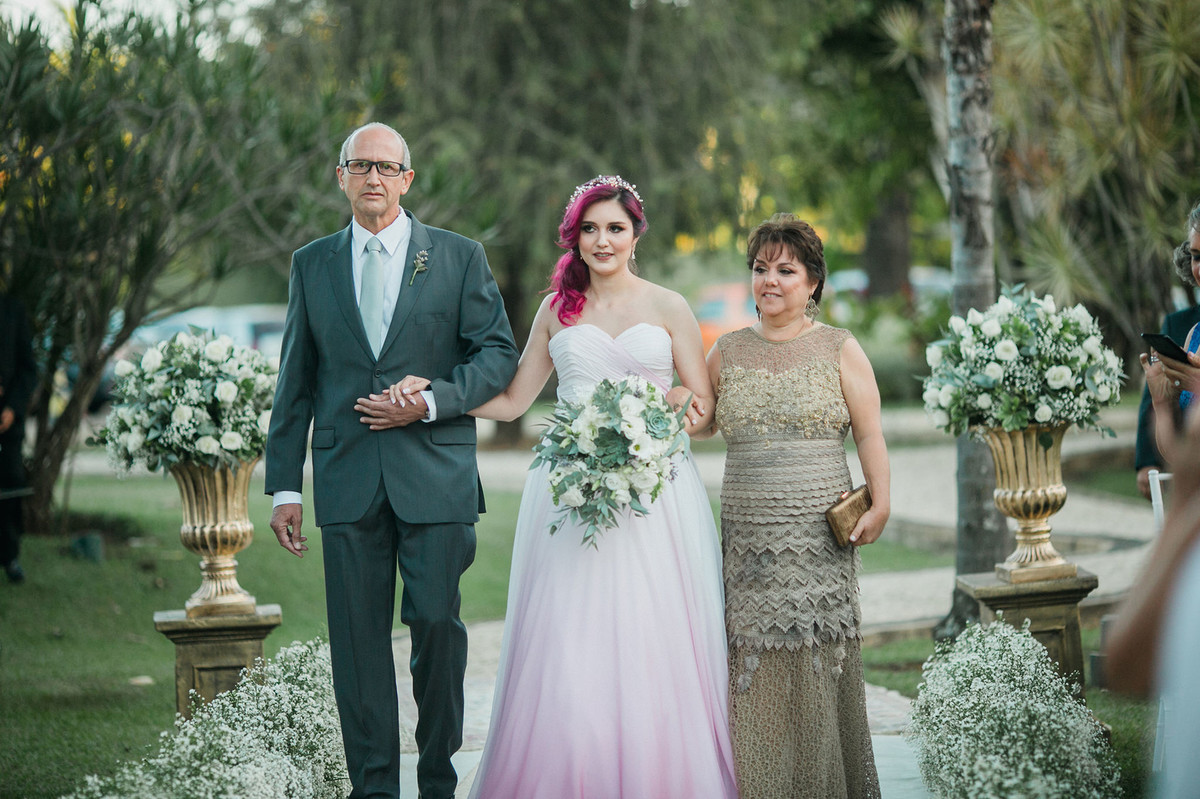 noiva com vestido rosa e cabelo rosa em seu casamento