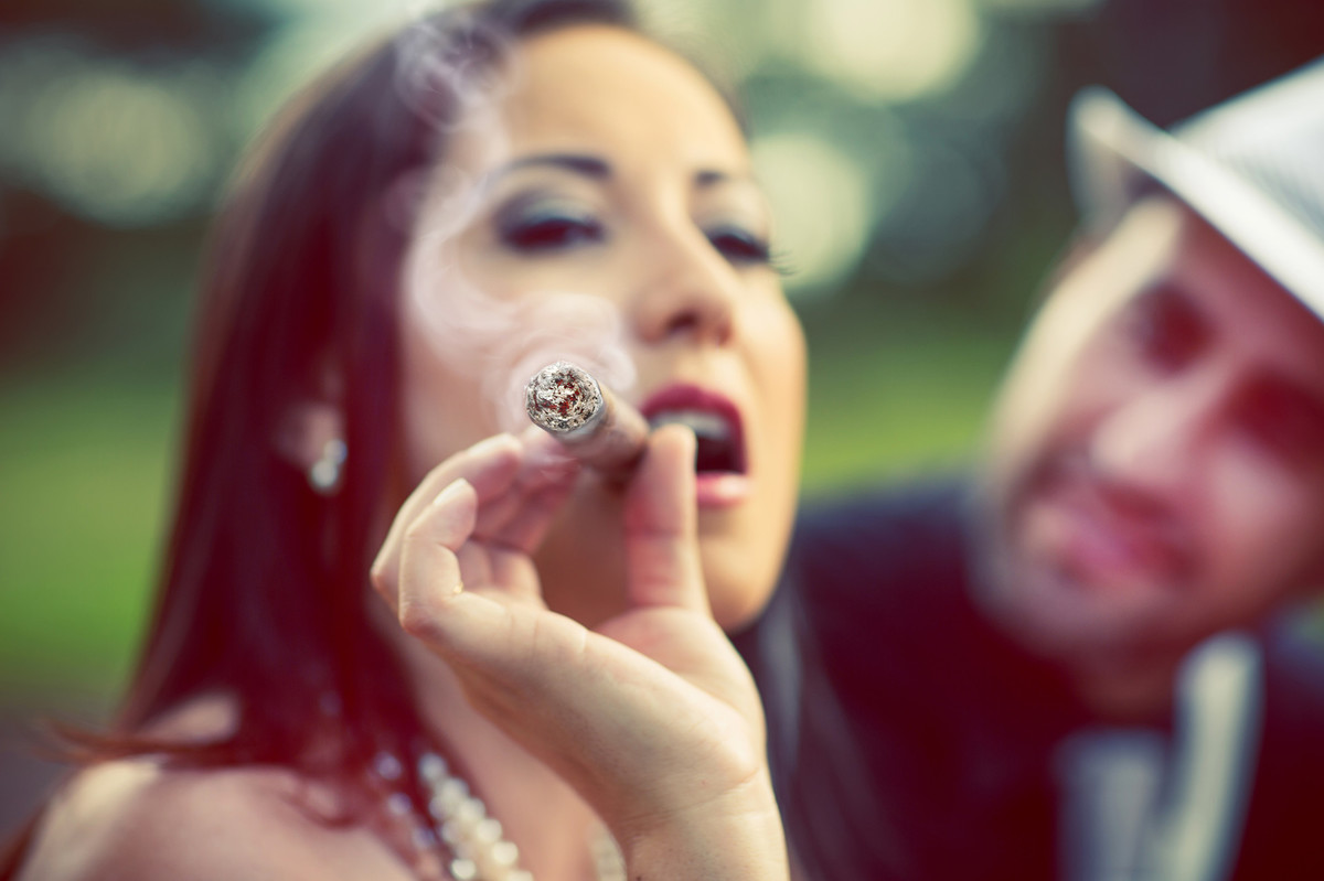 Ensaio de casal no estilo máfia feito pelo fotógrafo de casamentos de Brasília-DF. Noiva fumando charuto