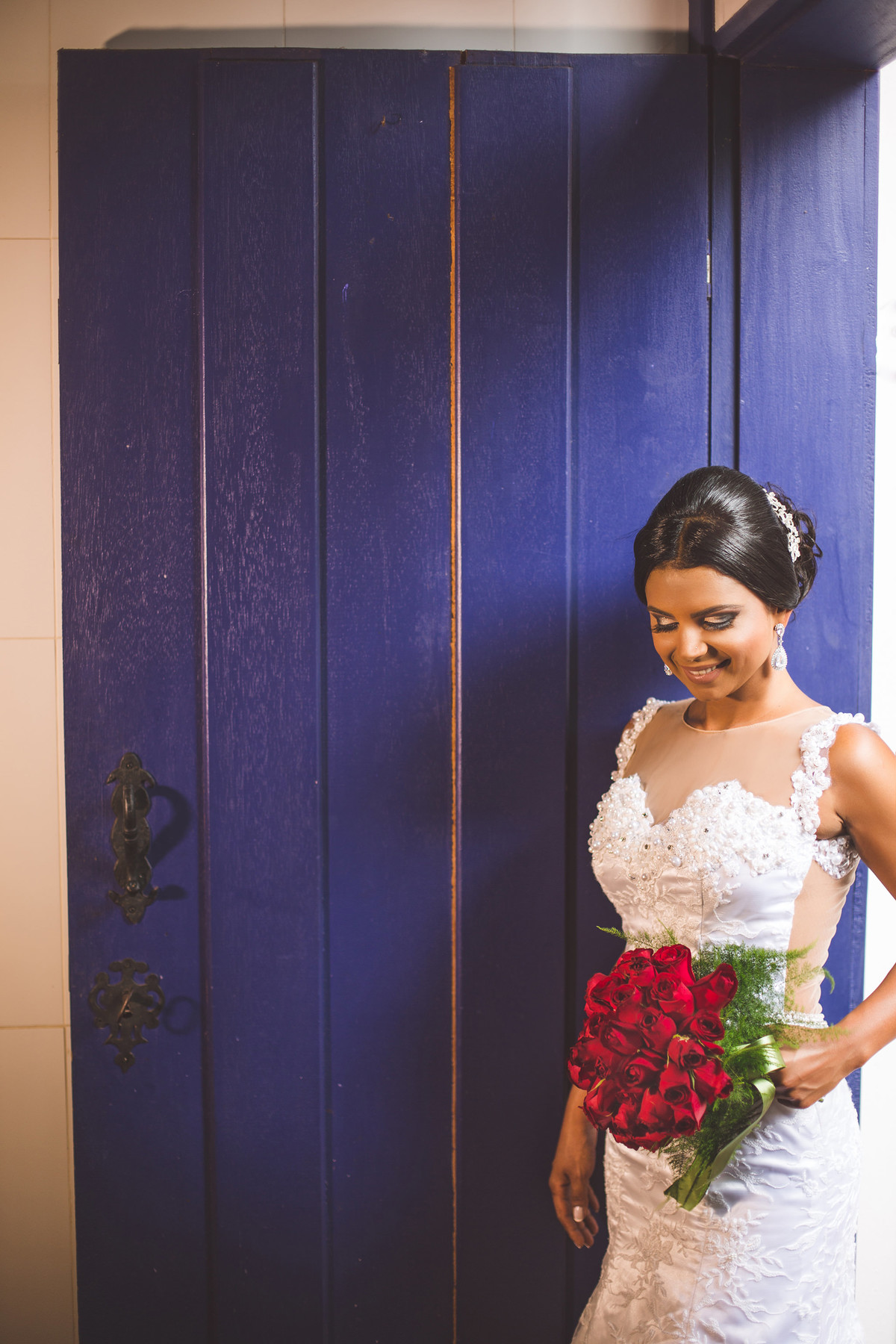 Noiva posando em porta azul foto feita pelo fotógrafo Rafael Ohana em Paracatu-M