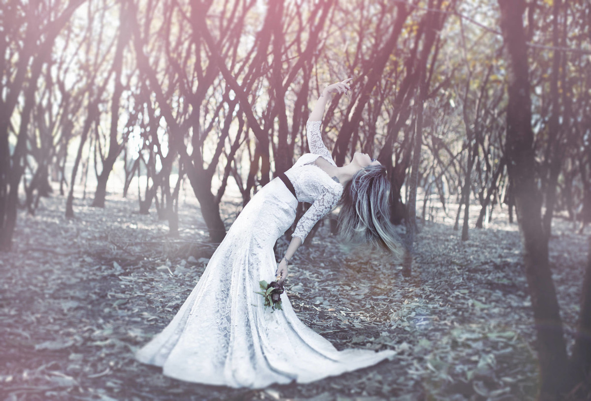 Noiva contorcendo o corpo segurando flores mortas em ensaio Trash the Dress feito pelo fotografo de casamentos Rafael Ohana em Brasilia-DF