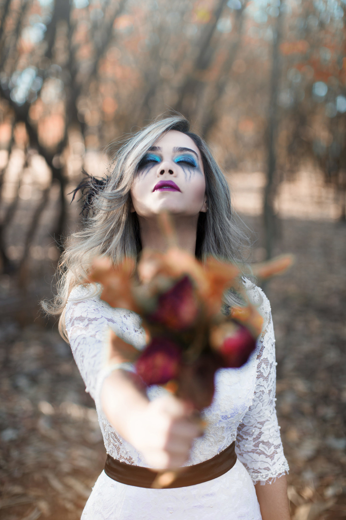 Noiva segurando buquê de flores mortas em ensaio trash the dress feito pelo fotografo de casamento Rafael Ohana em Brasilia-DF