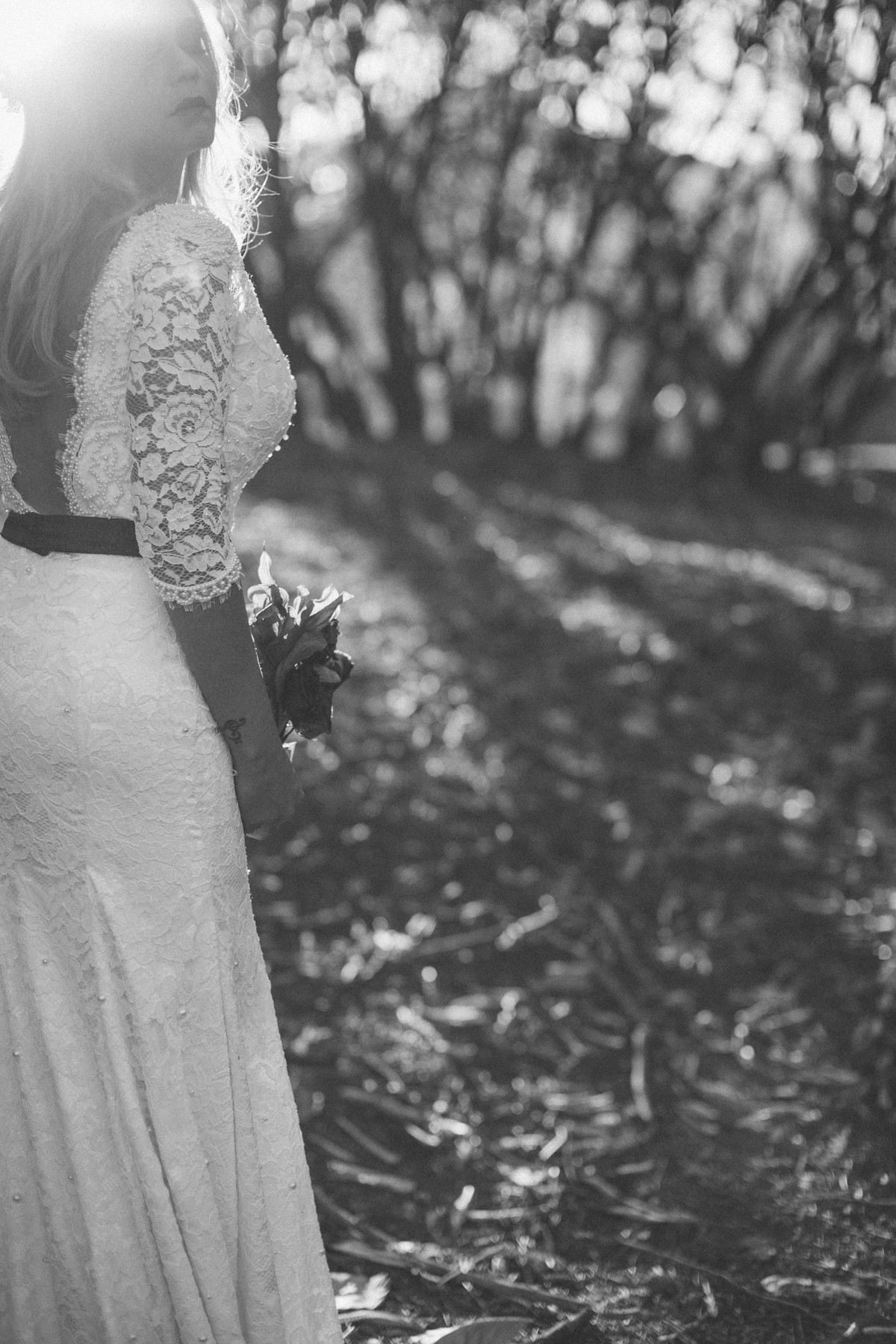 Noiva posando contra a luz segurando flores mortas feito pelo fotografo de casamentos Rafael Ohana em Brasilia-DF