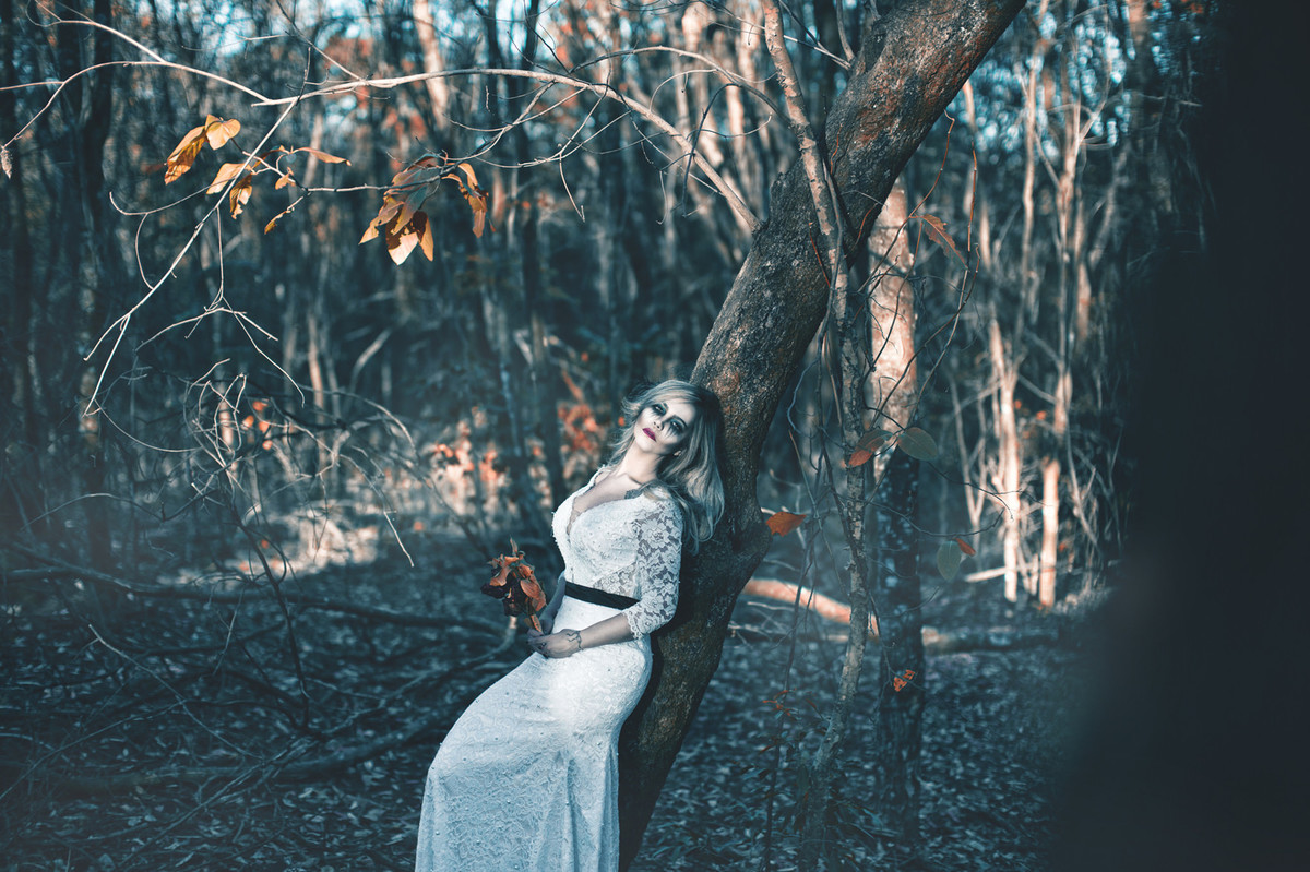Noiva encostada em árvore em ensaio trash the dress de halloween feito pelo fotografo de casamento Rafael Ohana em Brasilia-DF