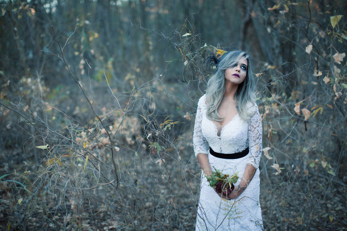 Noiva sozinha segurando flores mortas em ensaio trash the dress feito pelo fotografo de casamento Rafael Ohana em Brasilia-DF