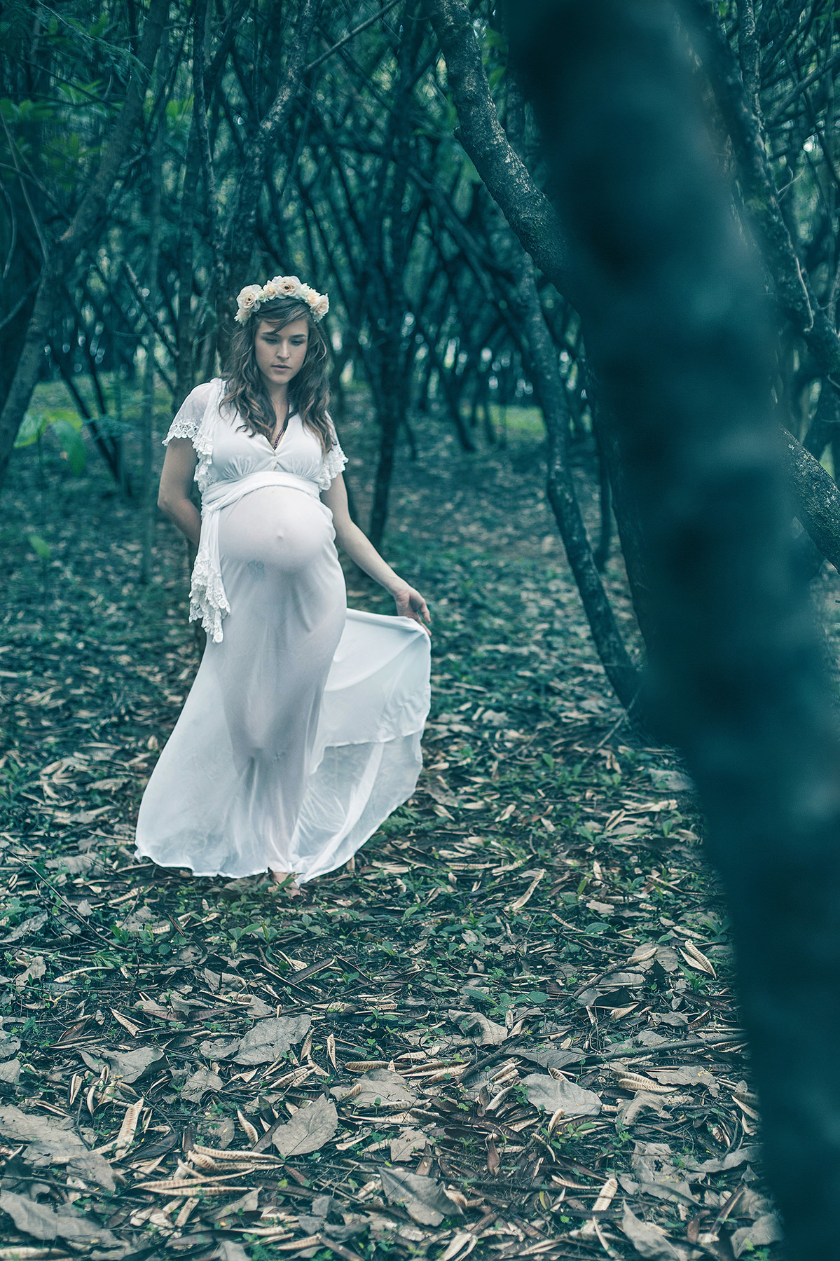 Gestante andando pela floresta com vestido branco
