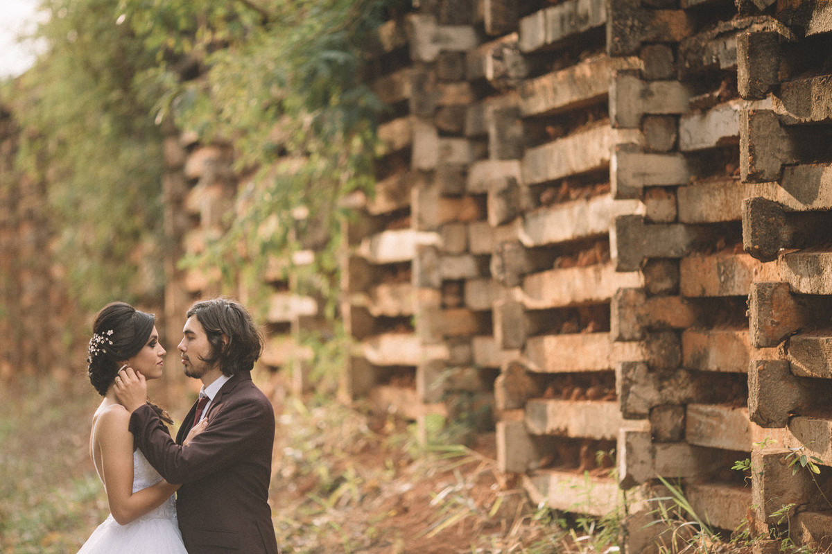 Casal de noivos se olhando perto de um muro alto. Fotografado pelo fotógrafo de casamento Rafael Ohana em Brasília-DF