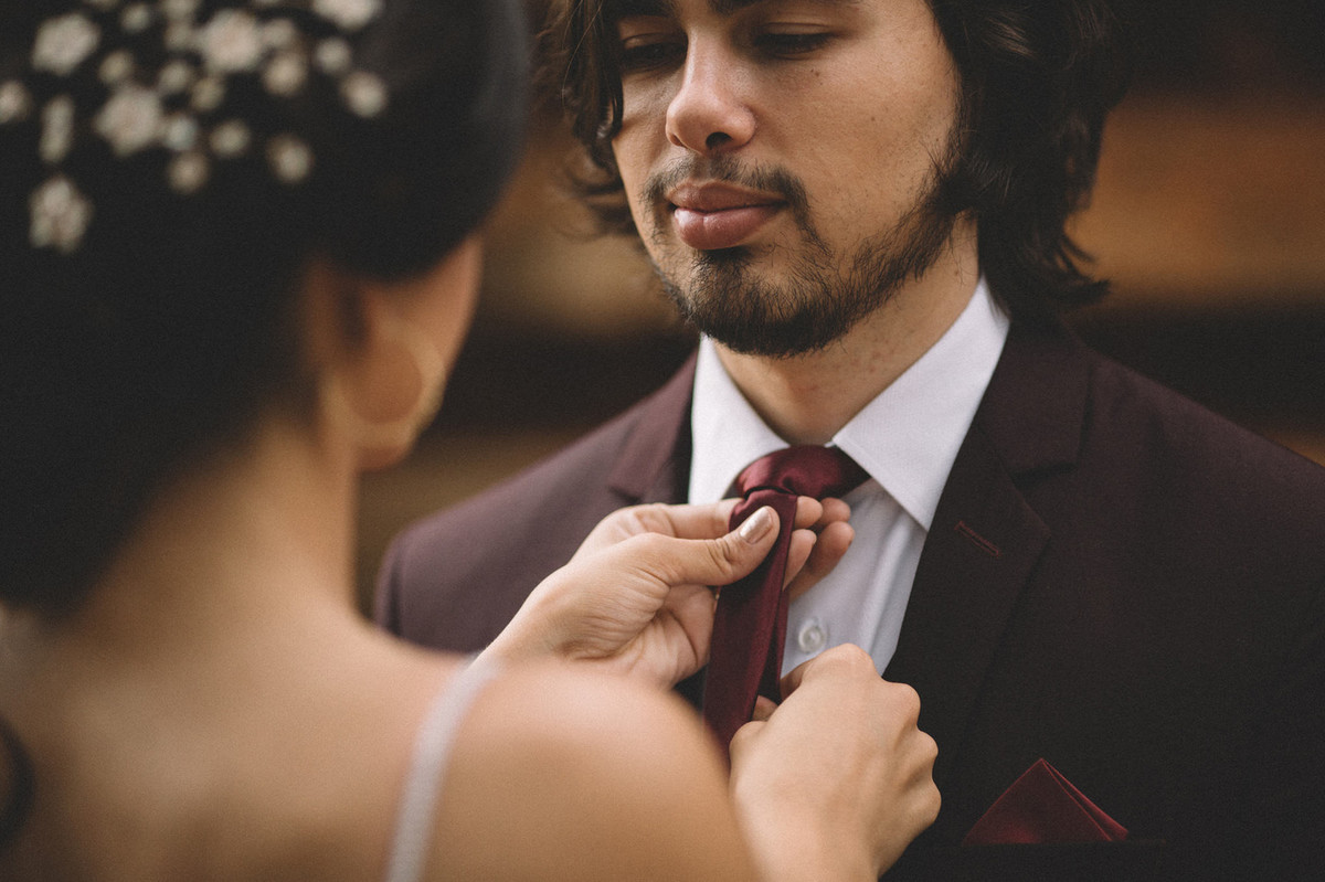 Noiva arrumando a gravata do noivo que olha pra ela. Fotografado pelo fotógrafo de casamento Rafael Ohana em Brasília-DF