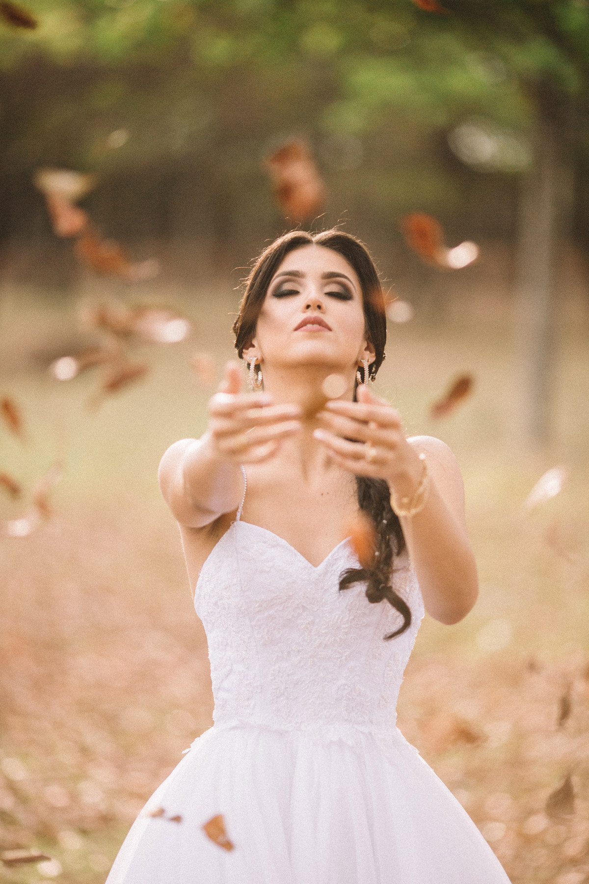 Noiva em meio a uma chuva de folhas. Fotografado pelo fotógrafo de casamento Rafael Ohana em Brasília-DF