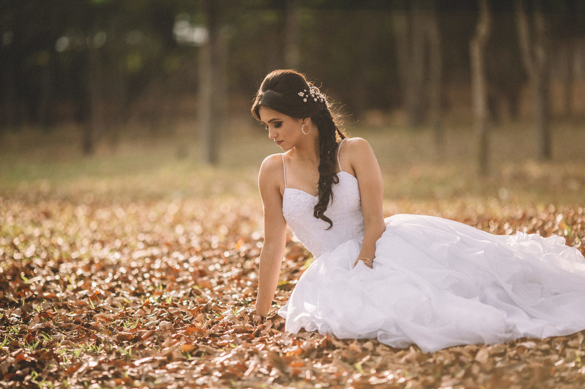 Noiva sozinha sentada no chão cheio de folhas. Fotografado pelo fotógrafo de casamento Rafael Ohana em Brasília-DF