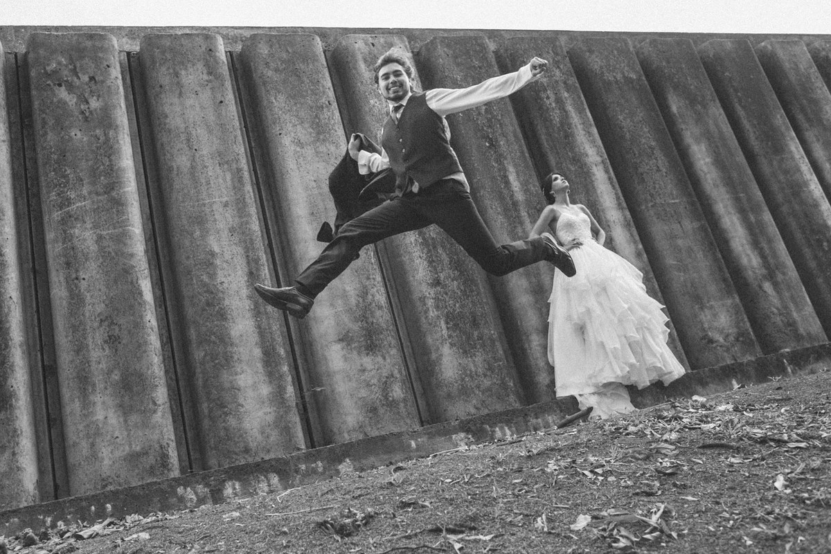 Noivo pulando alto enquanto noiva olha pra cima. Fotografado pelo fotógrafo de casamento Rafael Ohana em Brasília-DF