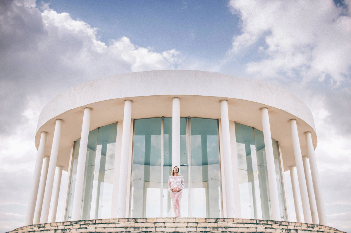 Gestante posando encostada em pilar de templo. Clicado pelo fotógrafo de gestantes Rafael Ohana em Brasília-DF