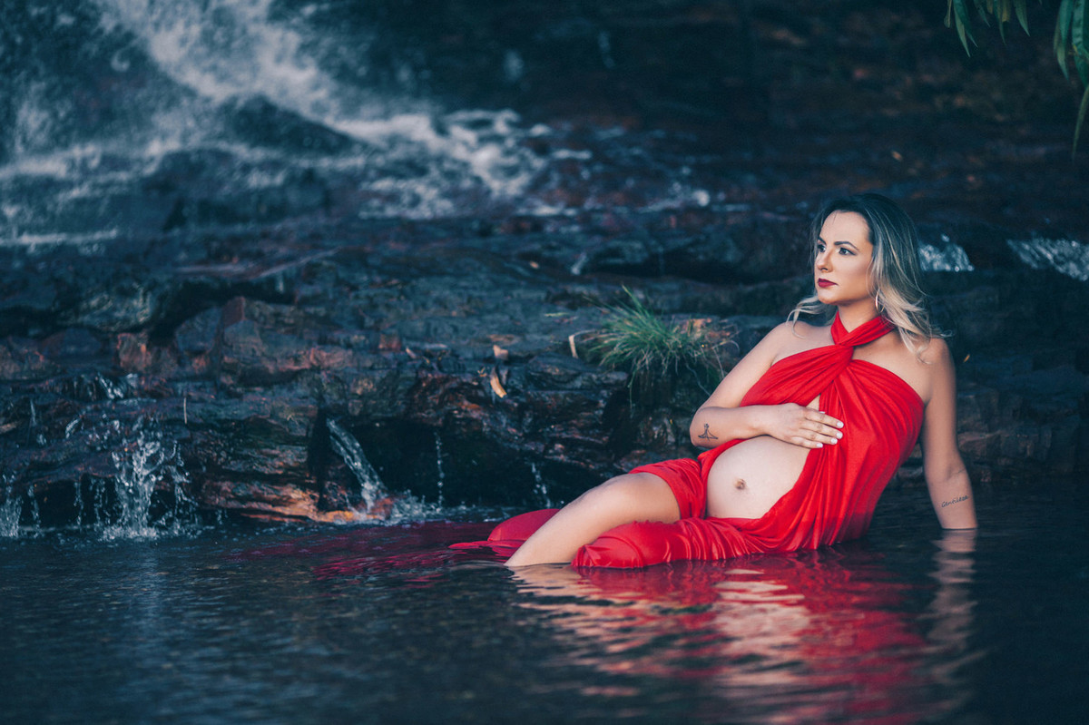 Grávida tomando banho de rio com vestido vermelho. Clicado pelo fotógrafo de gestantes Rafael Ohana em Brasília-DF
