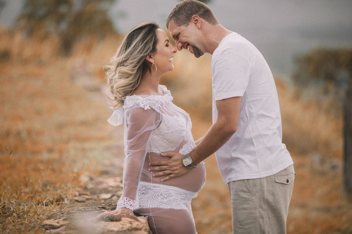 Loira grávida se divertindo e rindo com seu marido. Clicado pelo fotógrafo de gestantes Rafael Ohana em Brasília-DF