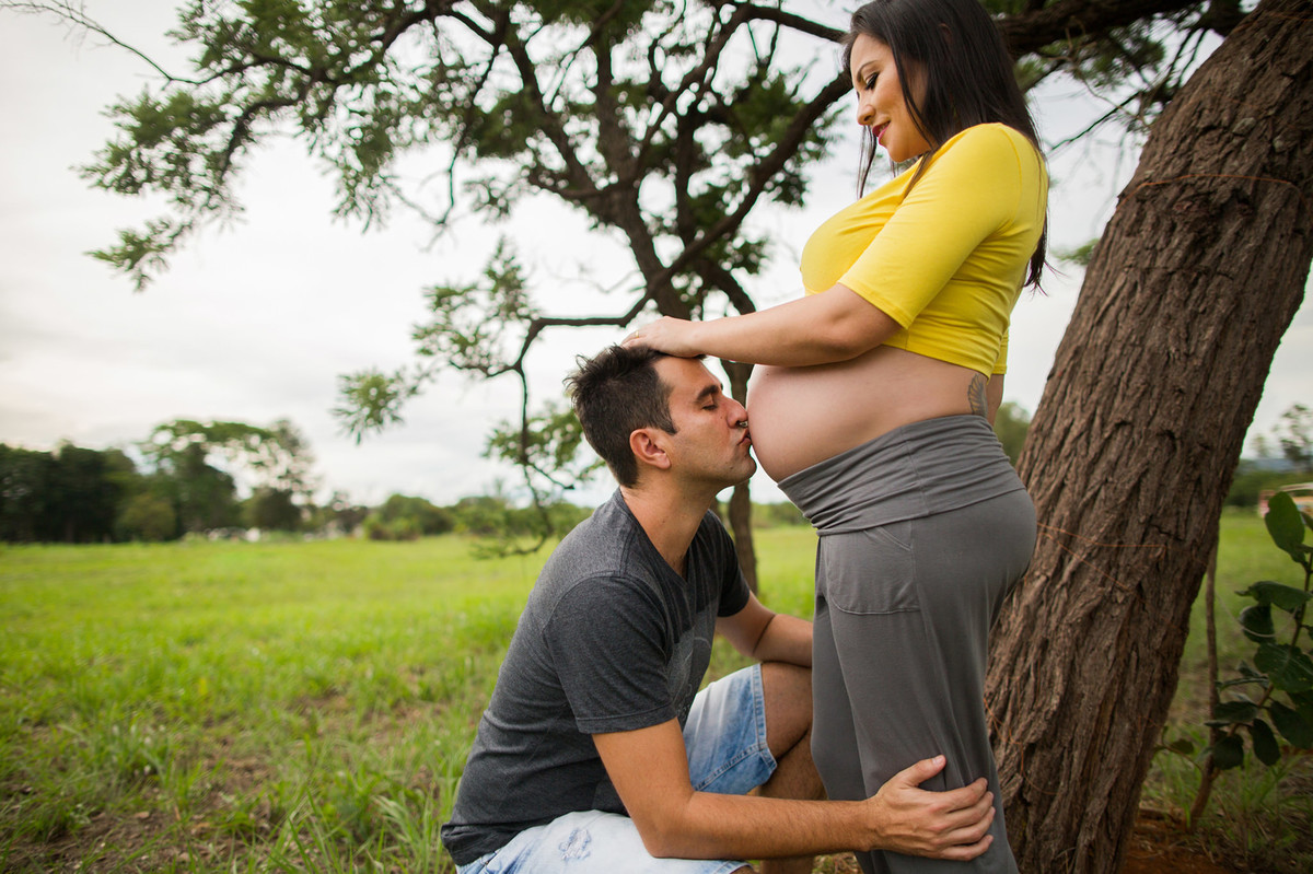 Marido beijando a barriga de esposa grávida. fotografia feita pelo fotógrafo de grávidas Rafael Ohana em Brasília