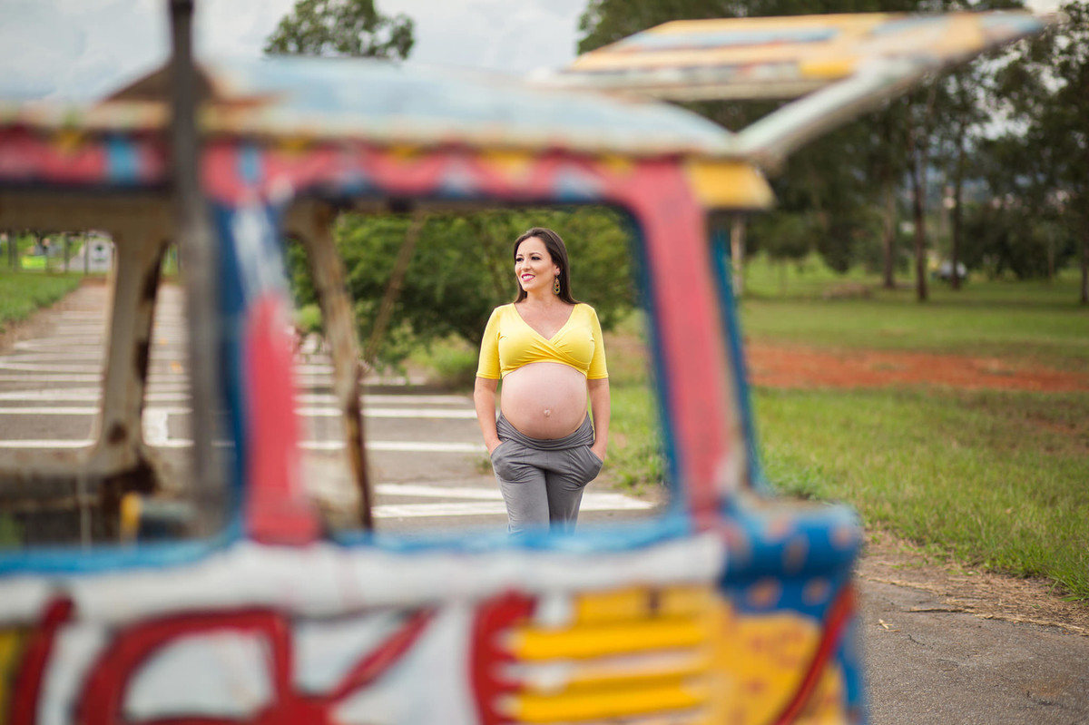 Gestante caminhando com as mãos nos bolsos. fotografia feita pelo fotógrafo de grávidas Rafael Ohana em Brasília